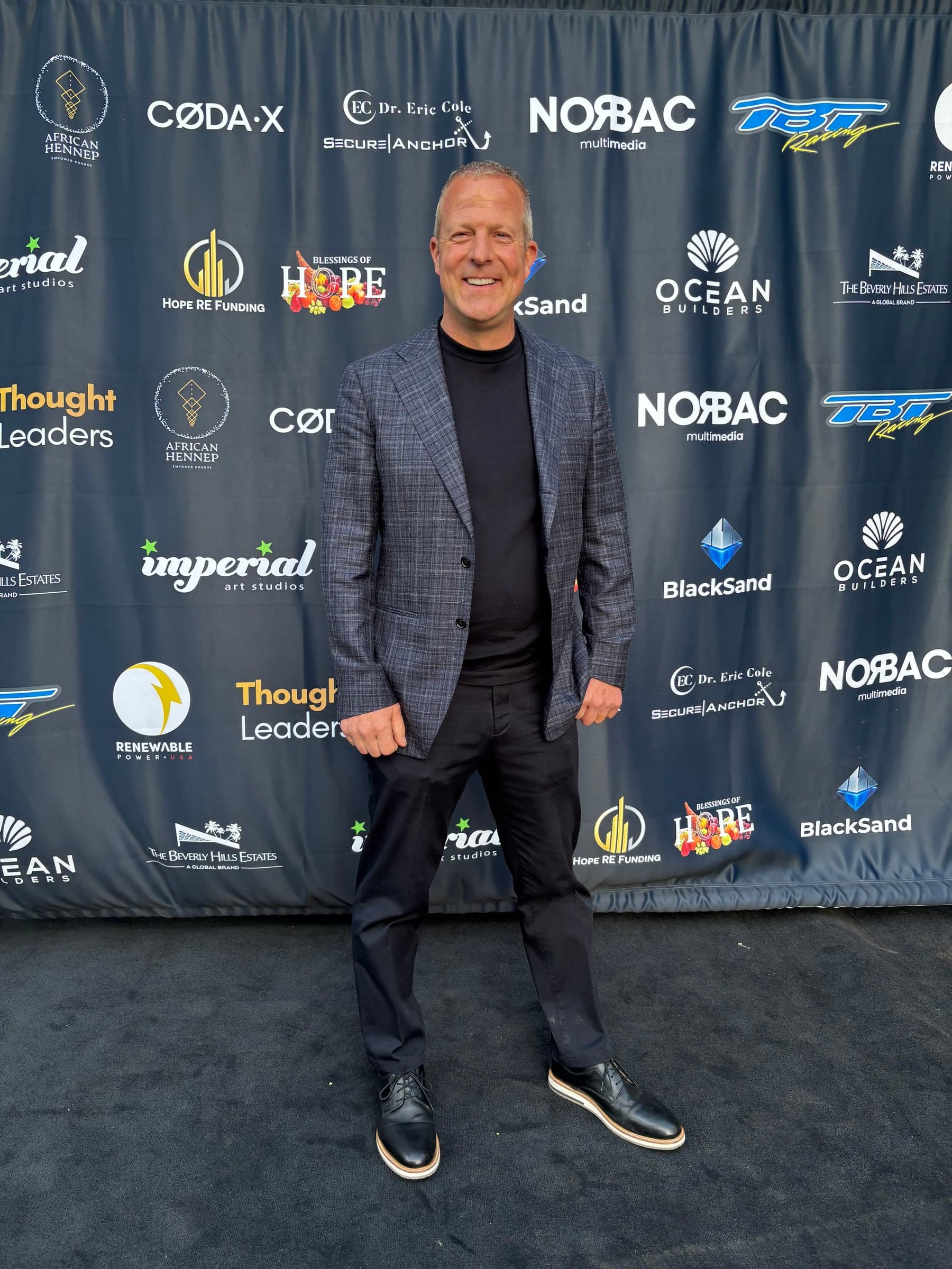 Travis Flateau at a branded event backdrop